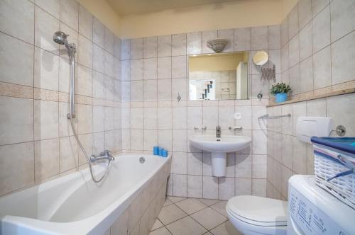 a bathroom with a tub and a toilet and a sink at Pokoje Monte 49 in Sopot