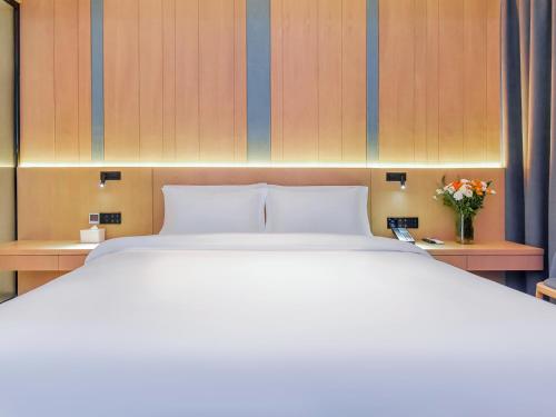a bedroom with a large bed and a vase of flowers at Lux CABINS一方山水 in Guilin