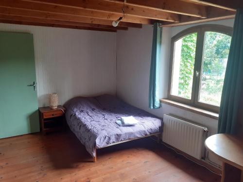 une petite chambre avec un lit et une fenêtre dans l'établissement Gîte à la ferme, à Montolieu