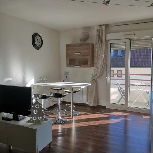 un salon avec une table et une télévision dans l'établissement Charming little apartment with bedroom, à Strasbourg