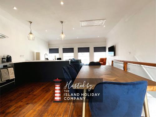 a kitchen and living room with a wooden table and chairs at Cross Street Apartment in Ryde