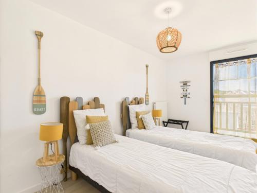 deux lits dans une chambre aux murs blancs dans l'établissement Appartement pour 6, plage de Pléneuf Val André, à Pléneuf-Val-André