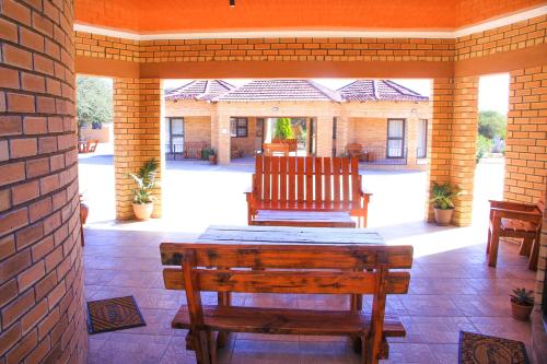 a patio with a table and chairs on a brick wall at Masiyabundu Guest House in Gaborone