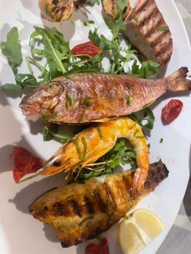two fish on a white plate with a salad at Dimora Marina sul Gargano in Vieste