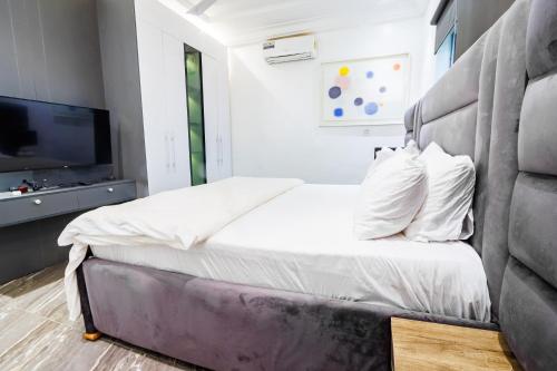 a bedroom with a bed and a television at Bawuah Royal Apartments in Kasi