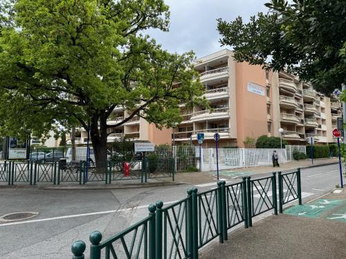 une clôture verte à côté d'une rue avec un bâtiment dans l'établissement Studio Centre Ville, à Sainte-Maxime