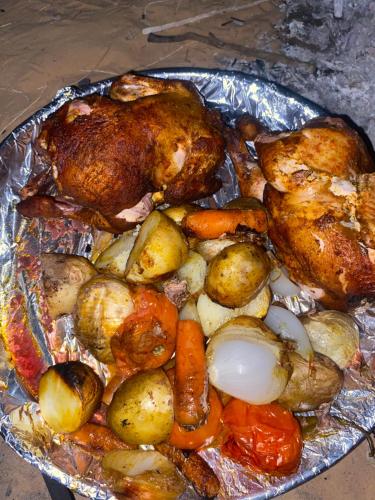 a tray of chicken and potatoes and vegetables at وادي رم إبوفيصل in Wadi Rum