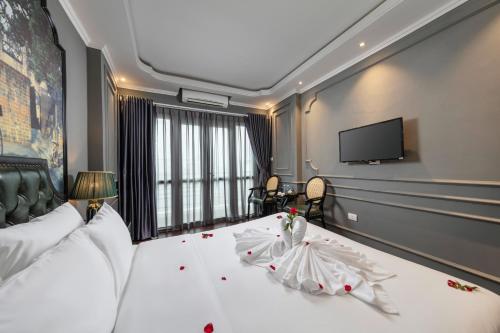 a bedroom with a large white bed with a flat screen tv at Hanoi View Hotel & Travel in Hanoi