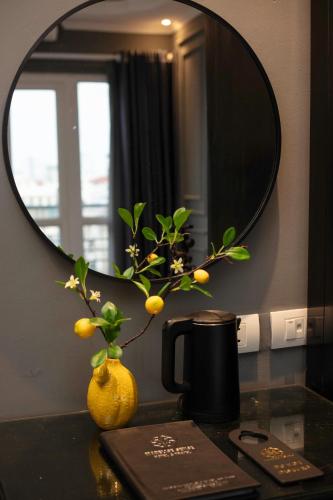 a mirror on a counter with a vase with a plant at Hanoi View Hotel & Travel in Hanoi