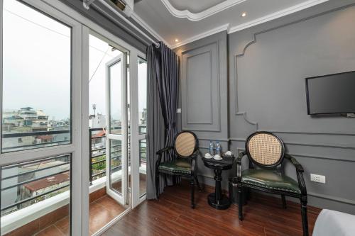 a room with two chairs and a table and some windows at Hanoi View Hotel & Travel in Hanoi