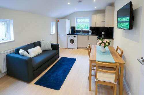 a living room with a couch and a table and a kitchen at Inviting 2-Bed Flat - near Finsbury Park in London