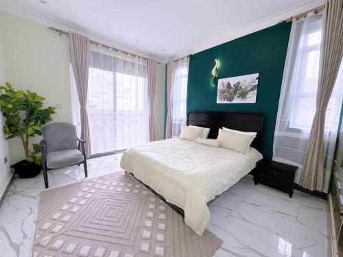 a bedroom with a bed and a green wall at Arana Royal Homes in Kampala