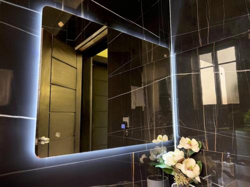 a mirror on a wall with a vase of flowers at Arana Royal Homes in Kampala