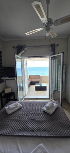 a bedroom with a bed with a view of the ocean at Filis mare apartment in Xylokastro