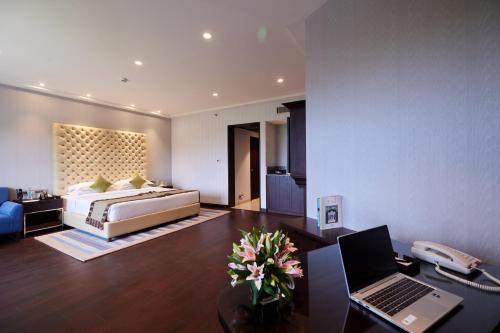 a bedroom with a bed and a desk with a laptop at Taj Deccan in Hyderabad