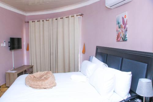 a bedroom with a large white bed with white pillows at Masiyabundu Guest House in Gaborone