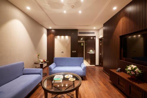 a living room with a blue couch and a tv at Taj Deccan in Hyderabad