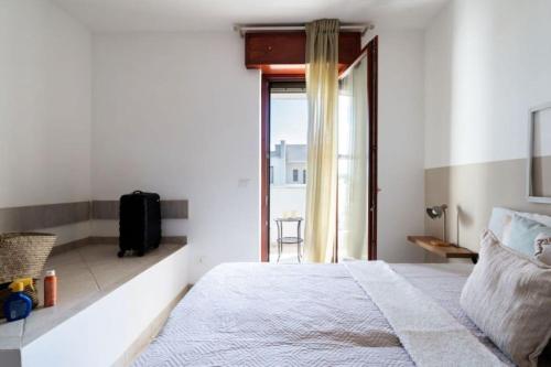 a white bedroom with a bed and a window at Villa Vitalis - 400 mt dalle spiagge in Torre Santa Sabina