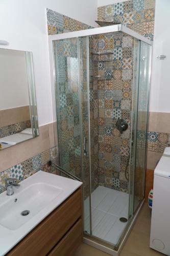 a shower with a glass door and a sink at Boulevard Holiday in Avola