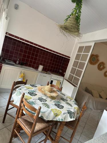 une cuisine avec une table et des chaises dans une pièce dans l'établissement Un petit coin de paradis soulac 33 n5, à Soulac-sur-Mer