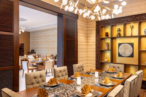 a dining room with tables and chairs and a chandelier at Taj Deccan in Hyderabad