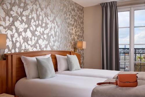 a hotel room with two beds and a window at Timhotel Montmartre in Paris