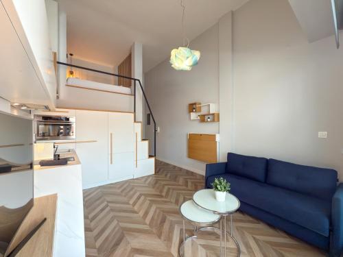a living room with a blue couch and a table at Luxury Downtown Apartment With Seaview E2 in Thessaloniki