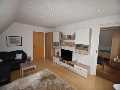 a living room with a couch and a television at Peaceful Apartment in Ostseebad Boltenhagen with Terrace in Boltenhagen