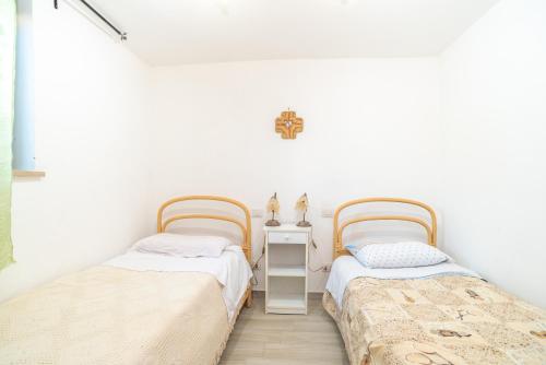 Dos camas en una habitación con paredes blancas. en Casa Francesco, en San Teodoro
