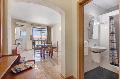 eine Küche und ein Wohnzimmer mit einem Waschbecken und einem Tisch in der Unterkunft Casa Enxame in Armação de Pêra