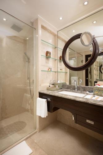 a bathroom with a shower and a sink and a mirror at Taj Deccan in Hyderabad