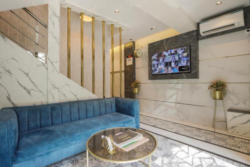 a living room with a blue couch and a table at Rich Hotel in Mumbai