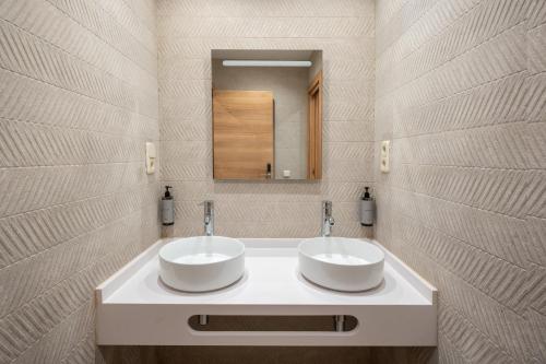 a bathroom with two sinks and a mirror at LUTHIA Puerta del Sol in Madrid
