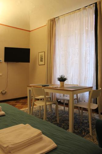 a room with a table and chairs and a window at Sancti Temporary Home Urbino in Urbino