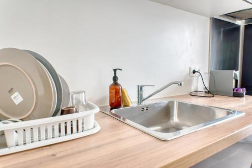 - un comptoir de cuisine avec un évier et une plaque de cuisson dans l'établissement Appartement Chic, à Saint-Ouen