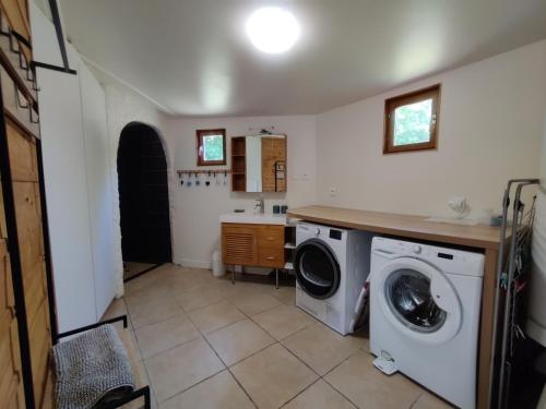 - une buanderie avec un lave-linge et un évier dans l'établissement Maison Plein Sud St Lunaire Bretagne, à Saint-Lunaire