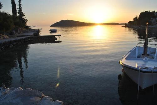a boat is docked at a dock in the water at 3 bedroom Apartment on the sea with garden in Ražanj