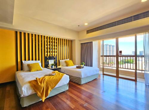 a hotel room with two beds and a balcony at Sunway Studio HomeStay Access Mall & next to Lagoon by Cloud Host in Petaling Jaya