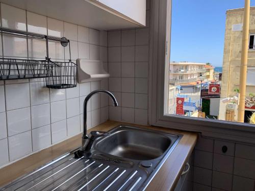 d'une cuisine avec évier et d'une fenêtre avec vue. dans l'établissement SP000-004 Appt 3 pièces 4 couchages SAINT PIERRE LA MER, à Saint Pierre La Mer