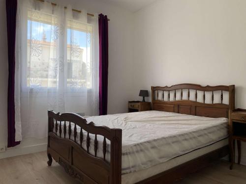 une chambre avec un lit en bois et une fenêtre dans l'établissement SP000-004 Appt 3 pièces 4 couchages SAINT PIERRE LA MER, à Saint Pierre La Mer