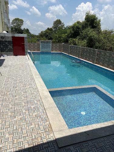 a swimming pool with blue water in a building at Art Le Cafe in Auroville