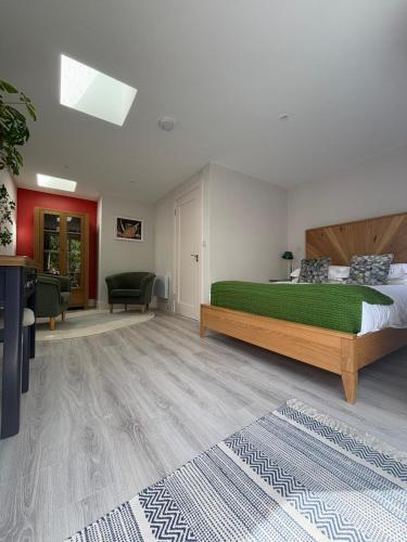 a bedroom with a large bed and a living room at Granville House Apartments and Garden Suites in Ballyferriter