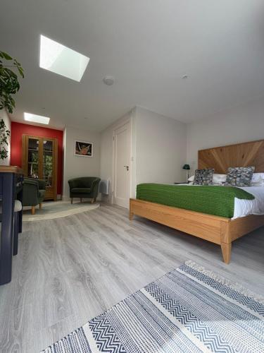 a bedroom with a green bed and a living room at Granville House Apartments and Garden Suites in Ballyferriter