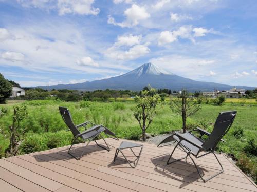 two chairs on a deck with a mountain in the background at SANGA Nature Fujinomiya in Fujinomiya