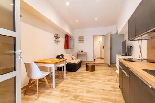 une cuisine et un salon avec une table et un canapé dans l'établissement Les appartements du vieux Poussan, à Poussan