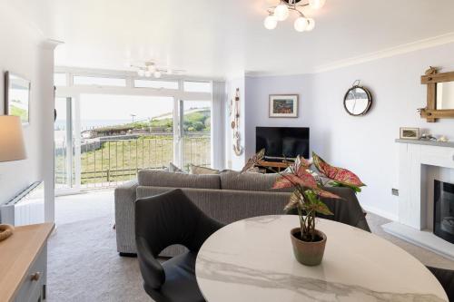 a living room with a couch and a table at NEW Beachfront Apartment slps 4, West Bay, Dorset in West Bay