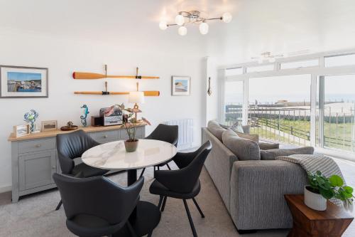 a living room with a couch and a table at NEW Beachfront Apartment slps 4, West Bay, Dorset in West Bay