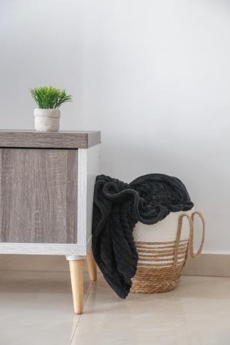 a black blanket sitting on a basket next to a table at 1-2BD Beach Apartments in Paphos
