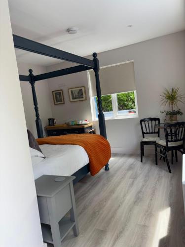 a bedroom with a bed and a table and chairs at Granville House Apartments and Garden Suites in Ballyferriter