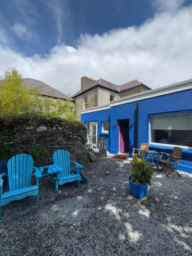 two blue chairs and a table in front of a blue building at Granville House Apartments and Garden Suites in Ballyferriter